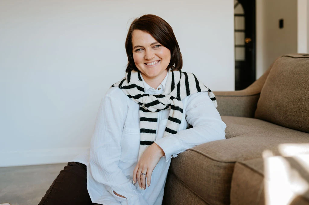 Mia Stultz seated on a sofa, smiling warmly